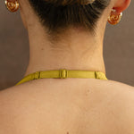 Yellow halter neck strap with adjustable buckle closure shown from back view on model.